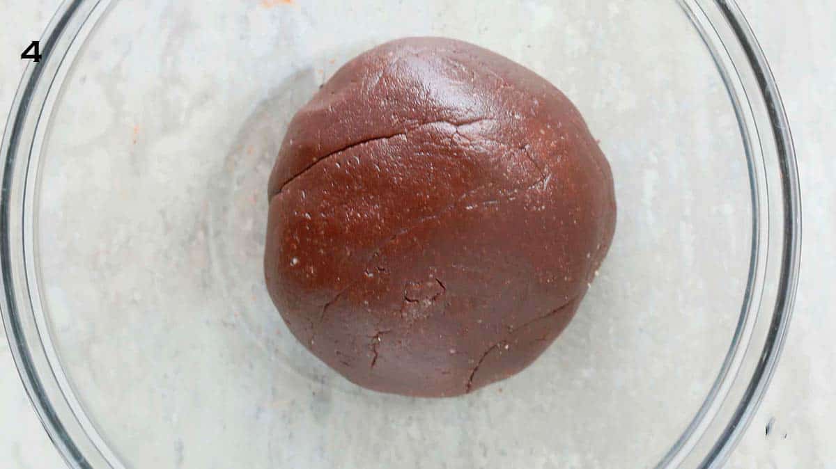 a ball of chocolate dough in a glass bowl.