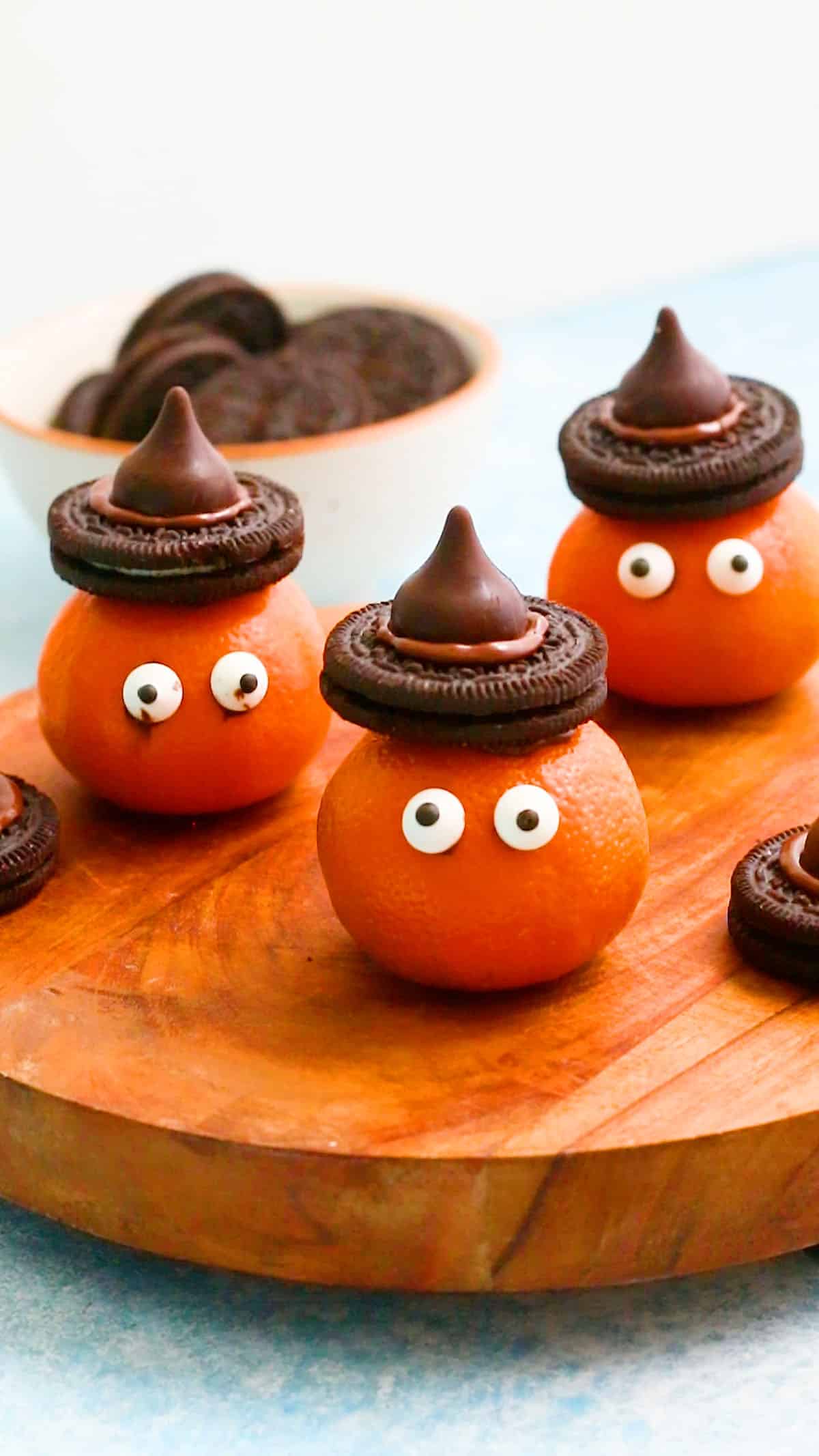 3 Halloween clementines with Oreo hats placed on  a wooden board.