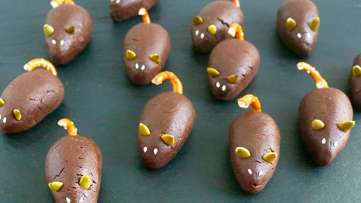 6 brown chocolate mice on a black board.