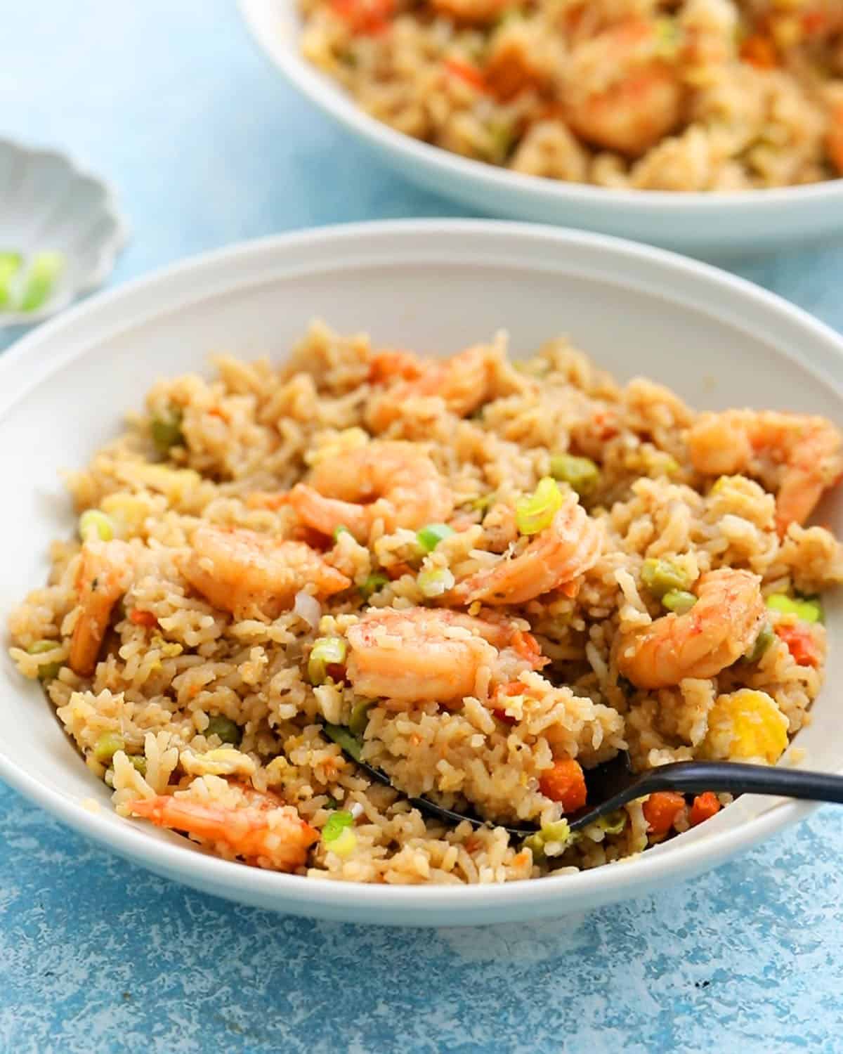 two white bowls with shrimp fried rice.