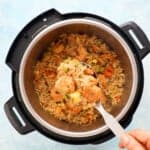 a spatula full of shrimp fried rice above an instant pot.