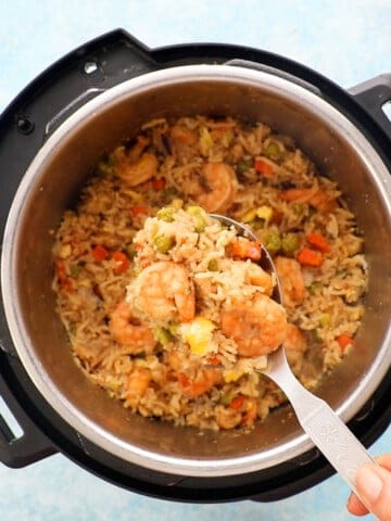 a spatula full of shrimp fried rice above an instant pot.