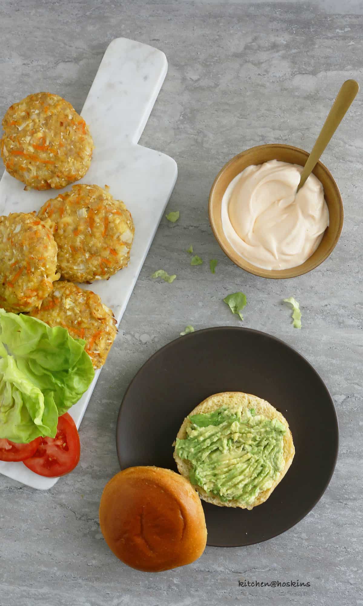 healthy chicken burger patties, mashed avocado, lettuce, tomato and sriracha mayo ready to assembled.