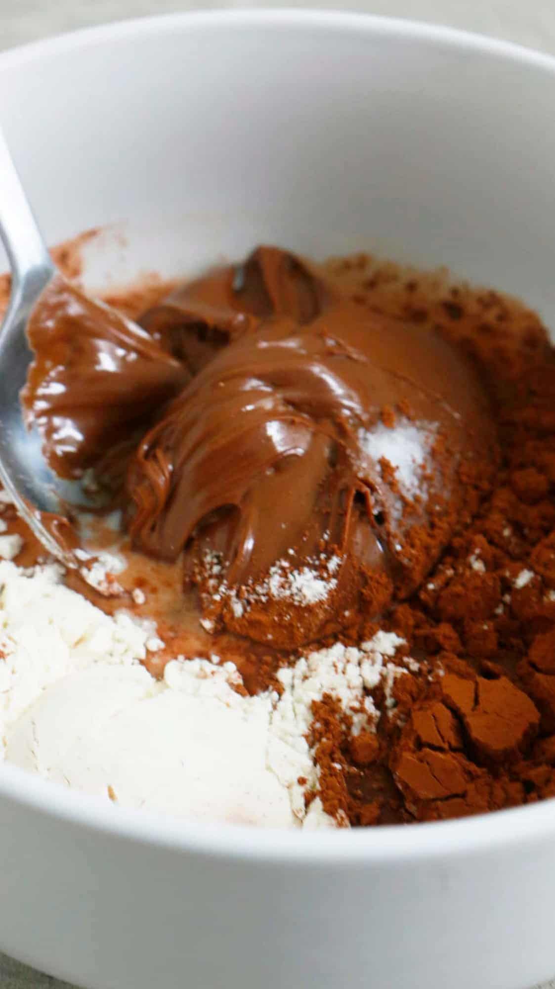 white bowl with Nutella and flour along with a spoon.
