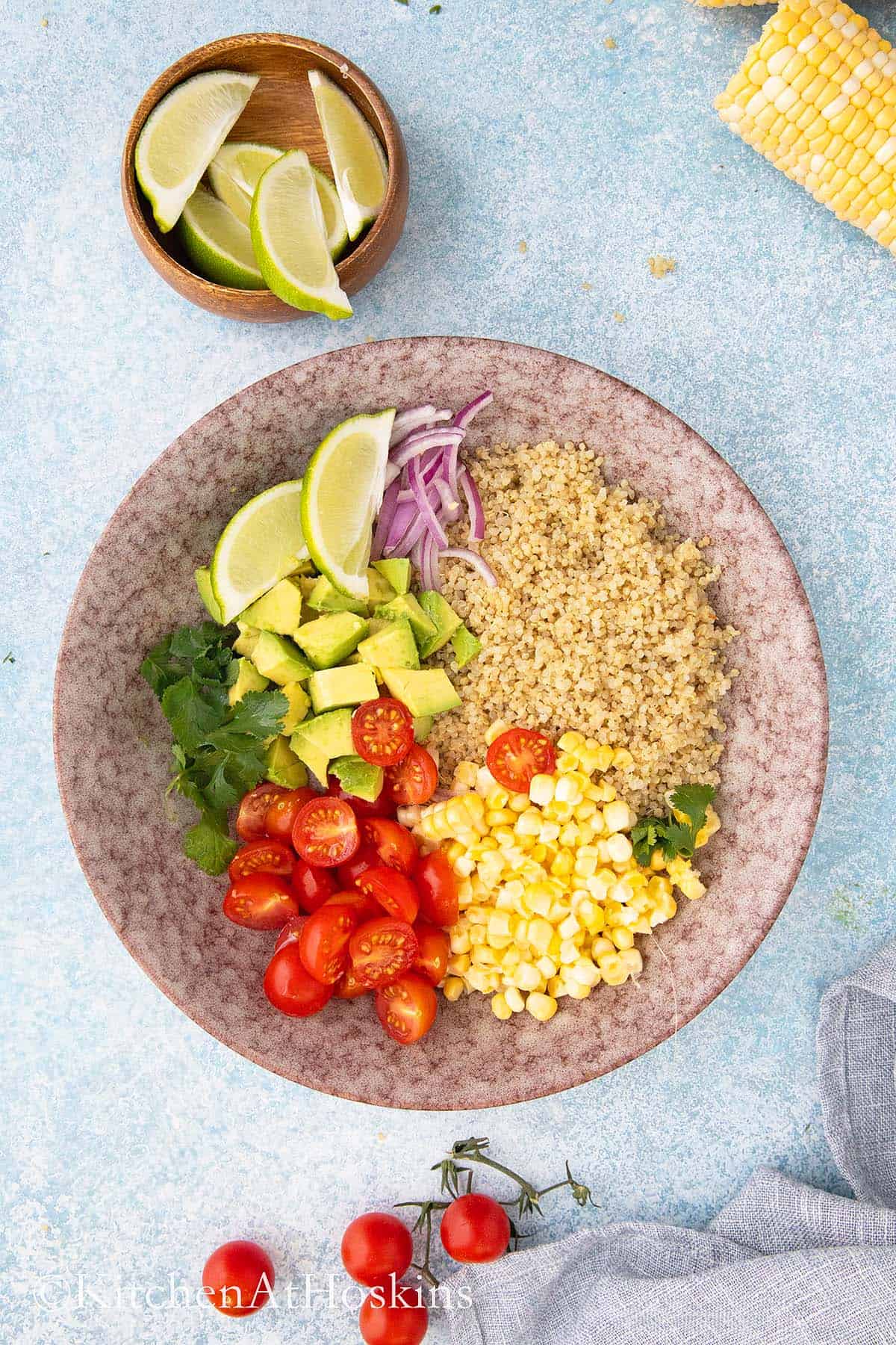 large pink bowl with all ingredients needed for a summer quinoa salad.