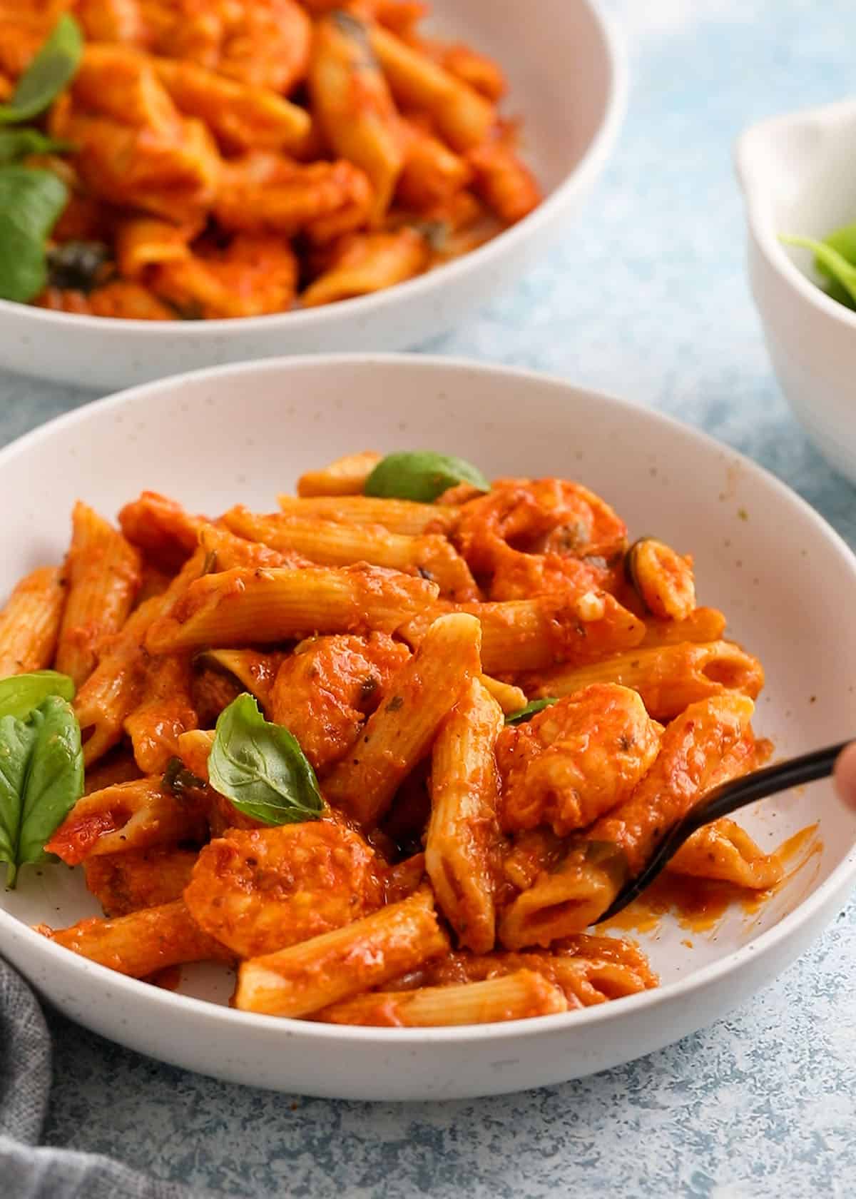 red shrimp pasta in two white bowls.