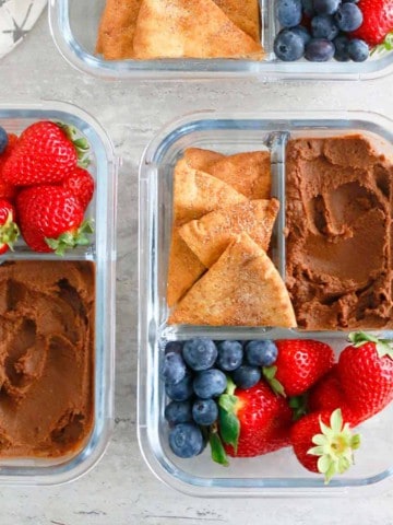 glass containers with sweet hummus, strawberries and pita chips.