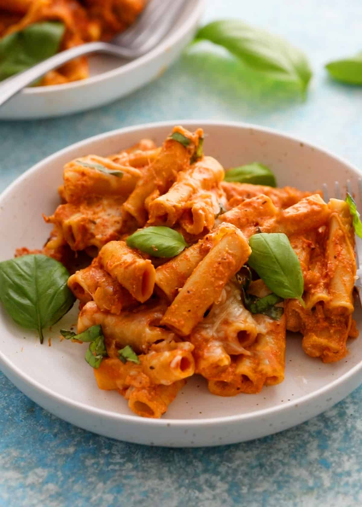baked ziti pasta in a white bowl.