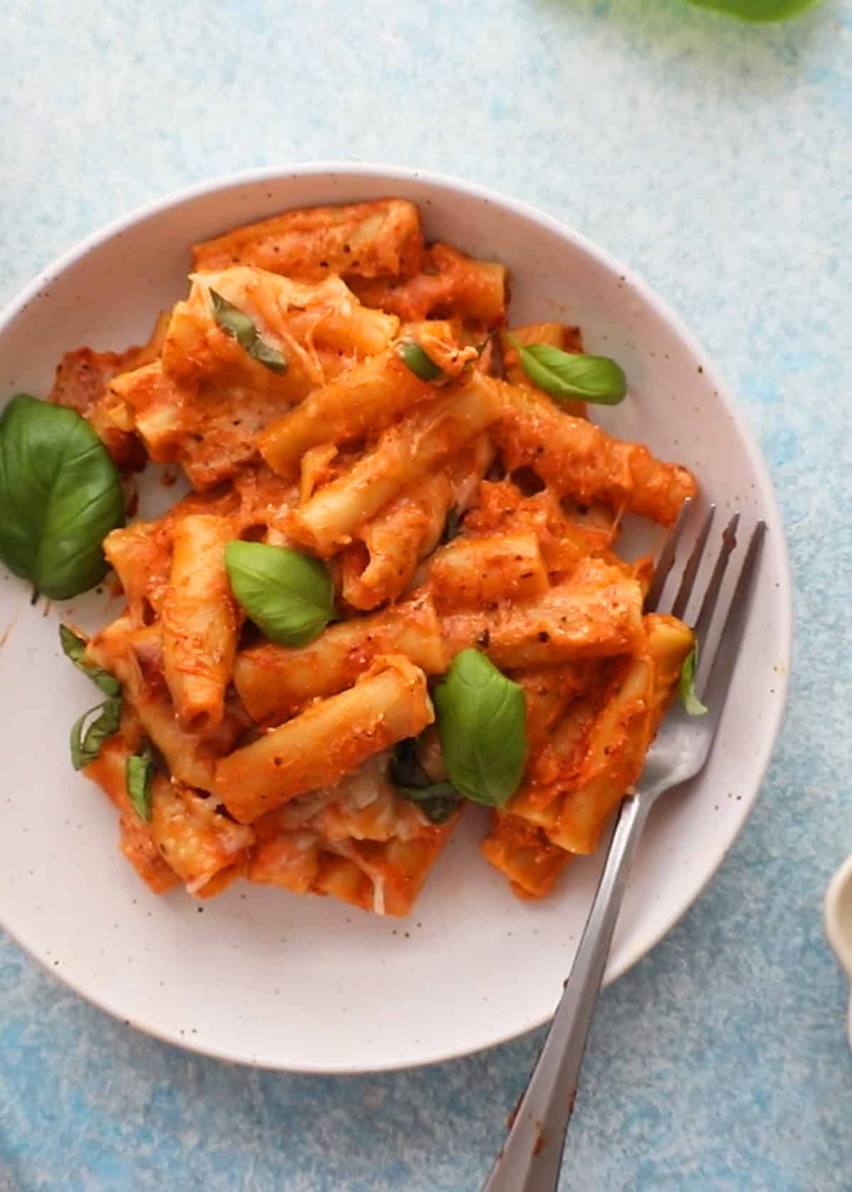 baked ziti pasta in a white bowl.