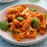 baked ziti pasta in a white bowl.
