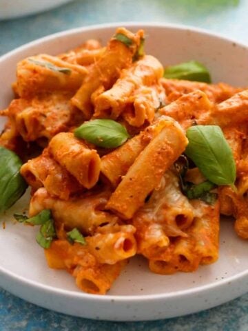 baked ziti pasta in a white bowl.