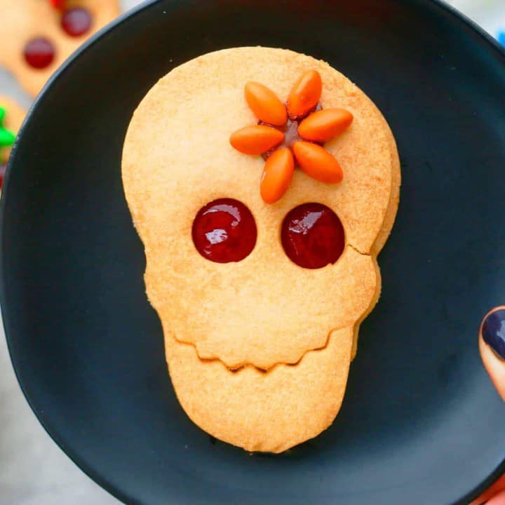 decorated halloween skull cookies on a plate.
