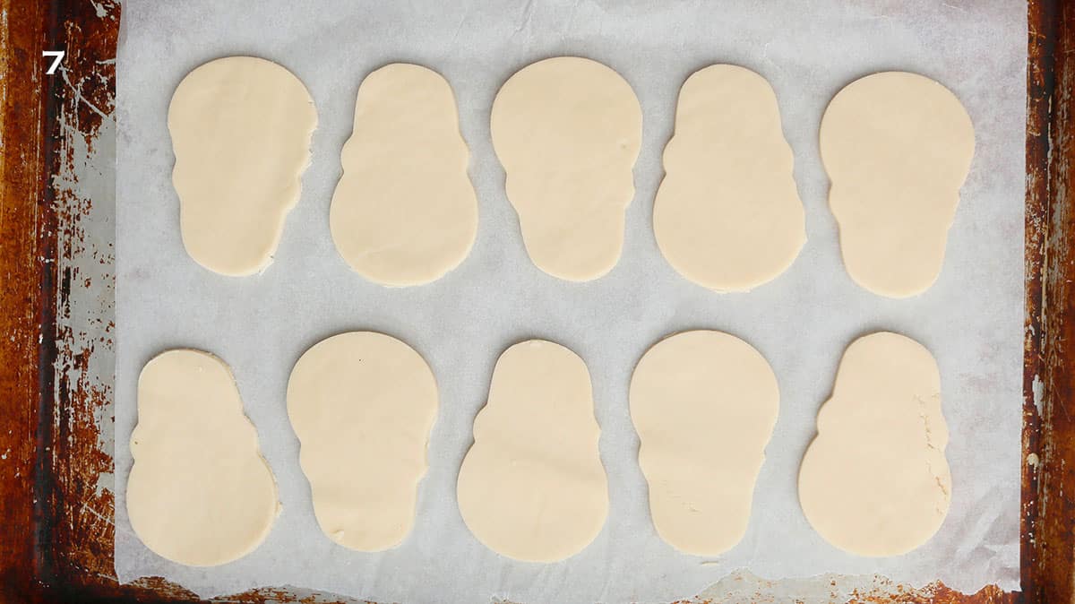 10 cut skull shaped cookie dough placed on a parchment lined baking sheet.