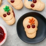 4 decorated skull shaped cookies on a white board.