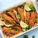 4 assembled fish tacos in a white tray.