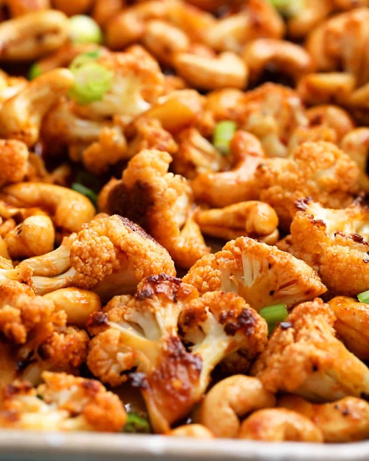 red colored Asian cauliflower and cashews in a sheet pan.