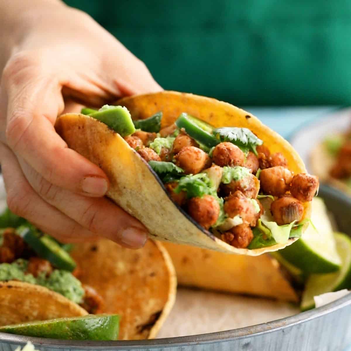 a hand holding one chickpea taco.