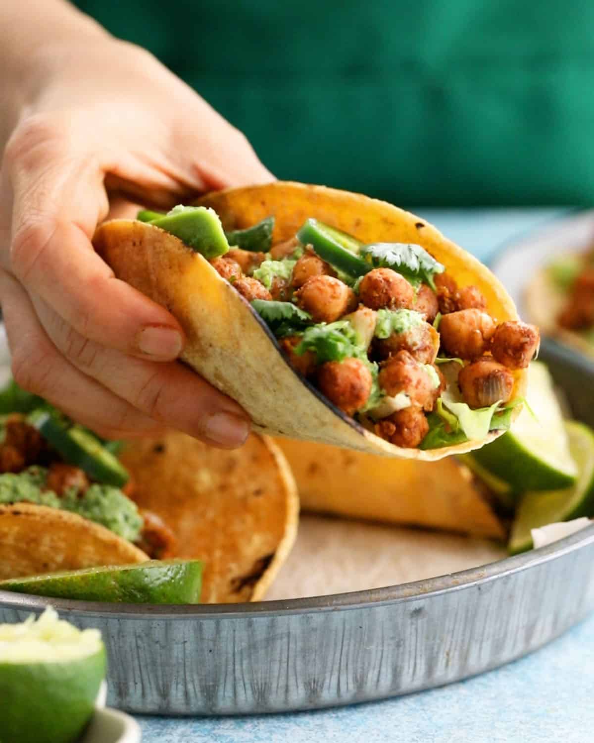 a hand holding one chickpea taco.