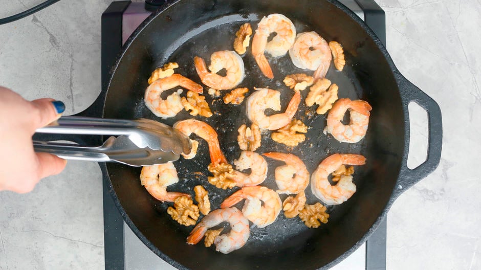 cooked shrimp and walnut in a pan