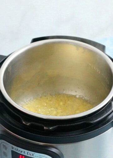 chopped garlic cooking in olive oil in an instant pot.