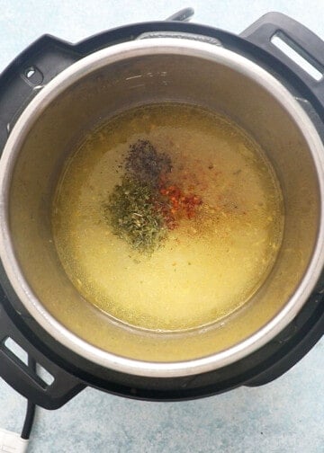 water along with red and green seasonings in an instant pot.