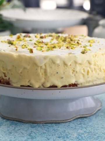 one yellow kulfi ice cream cake in a white cake stand.