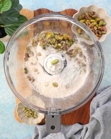 green pistachios and white flour in a food processor.