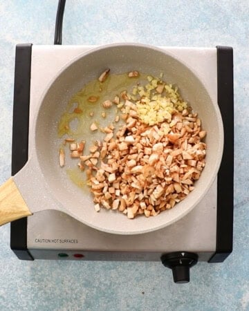 chopped mushrooms and garlic in a white skillet.