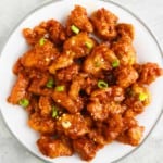 honey sriracha chciken in a white plate.