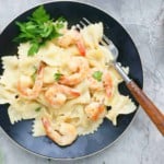cooked chicken alfredo pasta in a black plate.