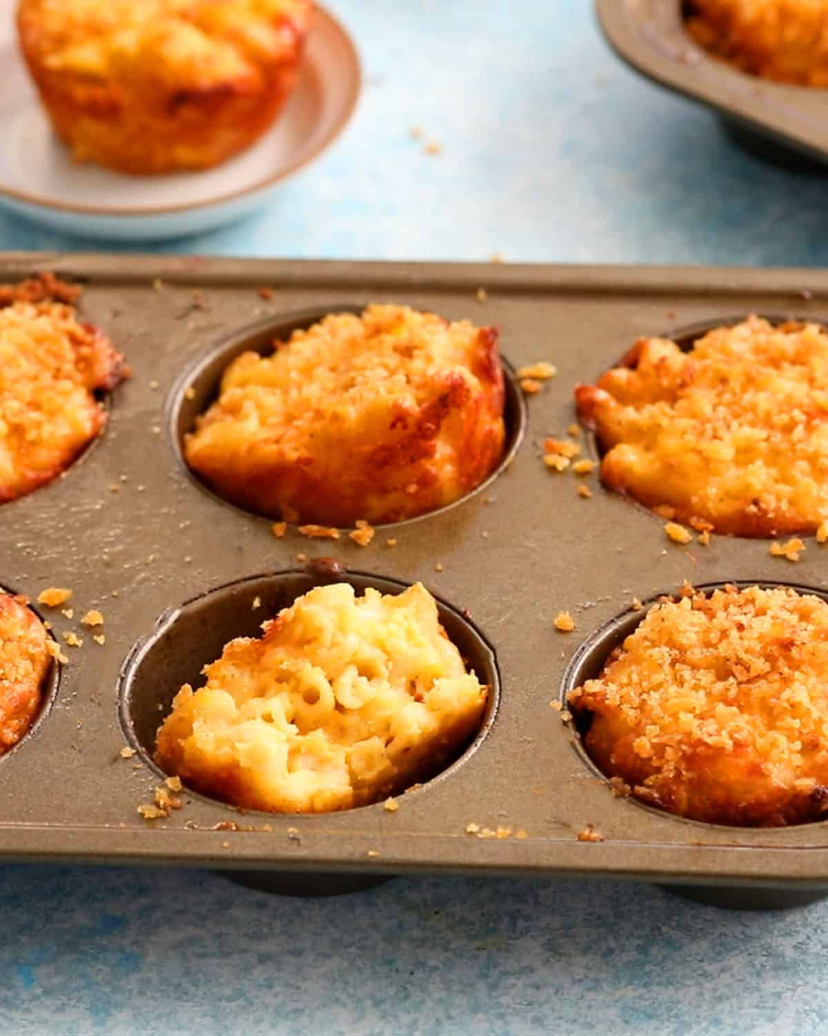 baked mac and cheese cups in a metal muffin pan.