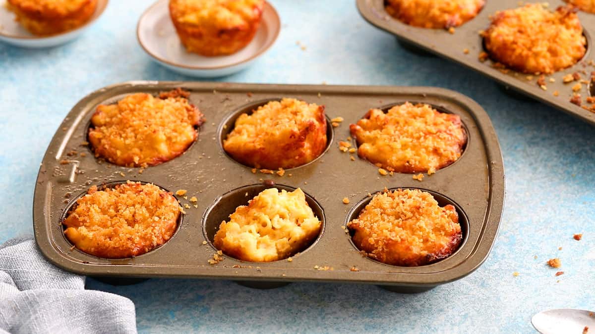 baked mac and cheese cups in a metal muffin pan.