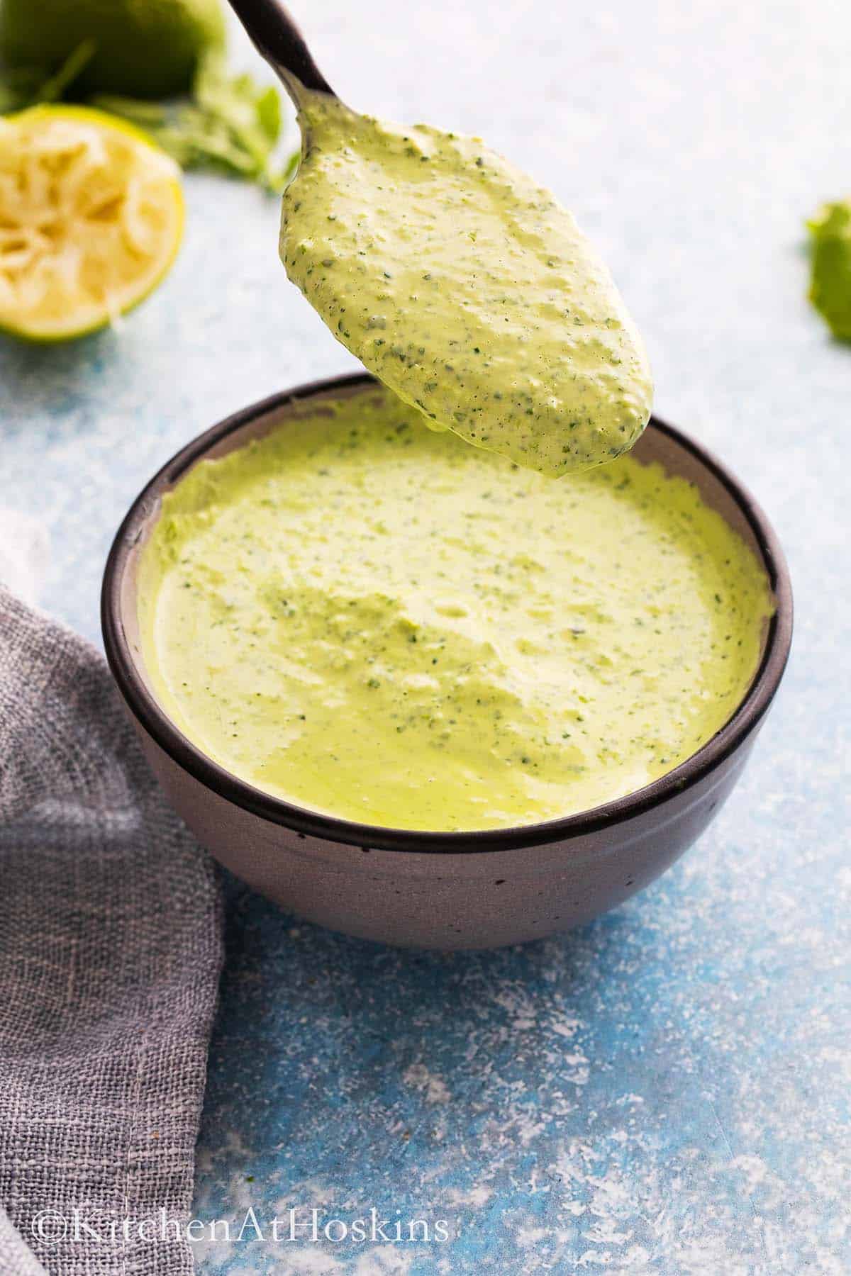 a spoonful of creamy green sauce over a bowl filled with the same.
