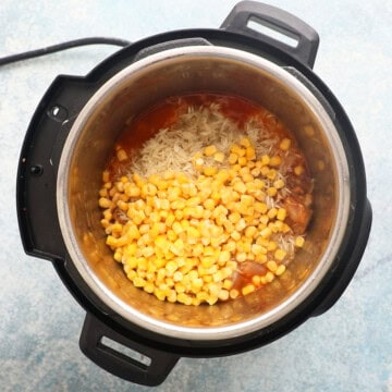 corn, raw rice along with red broth in an instant pot.