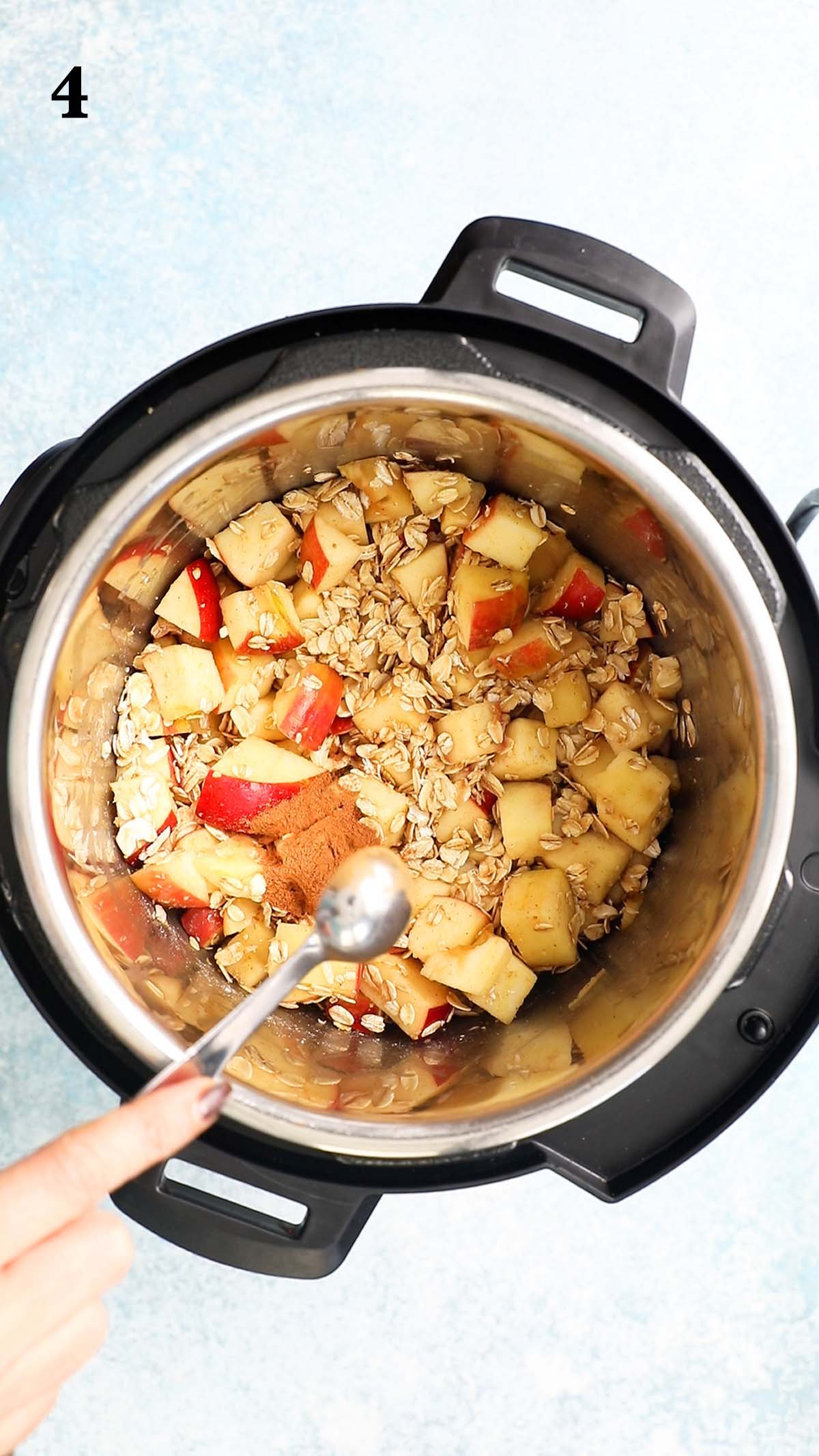 adding ground cinnamon into an instant pot with apple and oats.