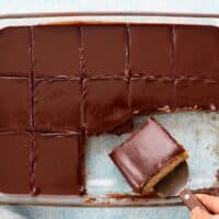 brown chocolate topped banana cake in a glass dish.