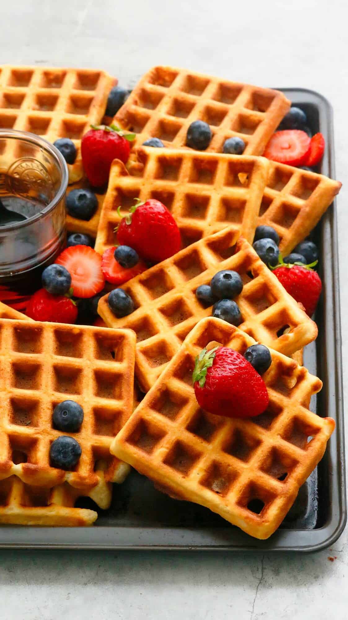 a baking sheet full of best Belgian waffles and maple syrup.