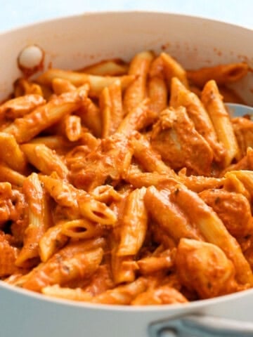 butter chicken pasta in a white skillet.