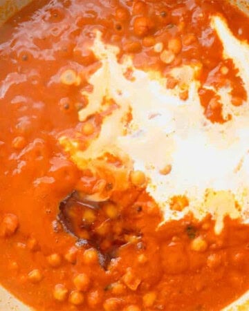 orange sauce and white heavy cream in a white pan.