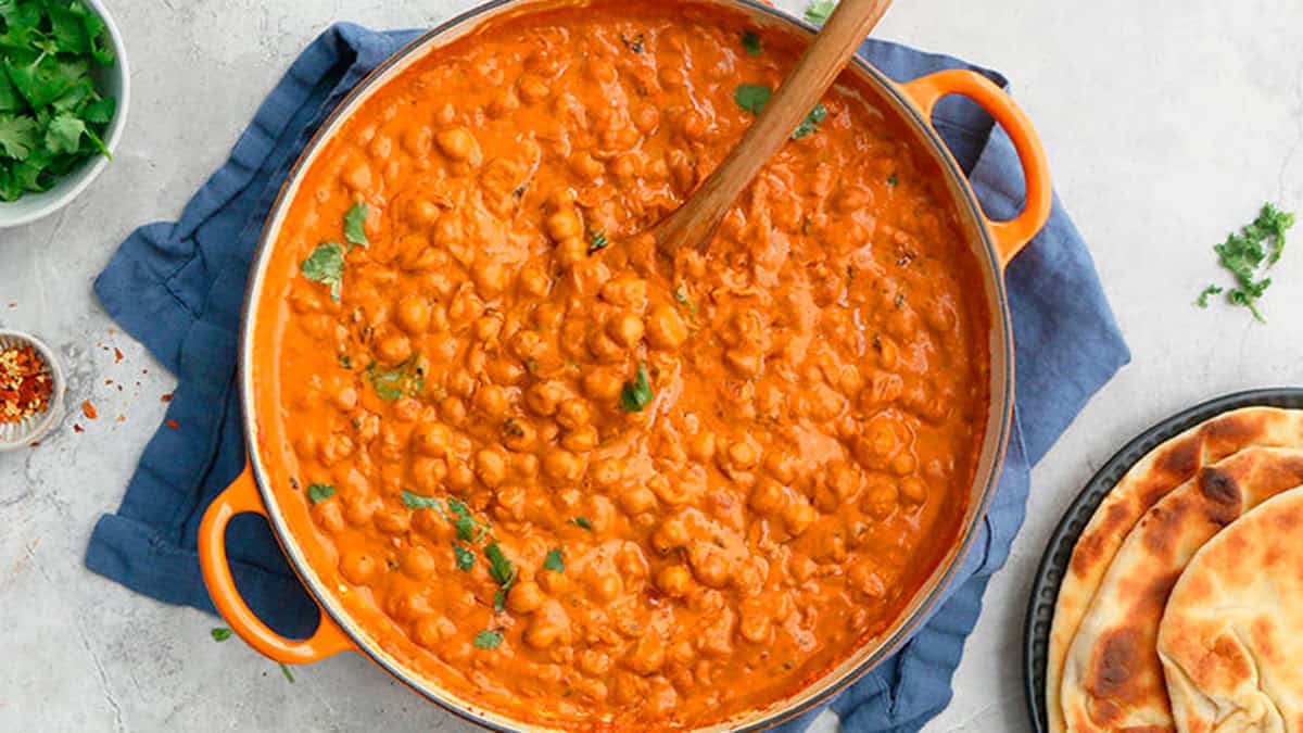 orange chickpeas curry in an orange pan.