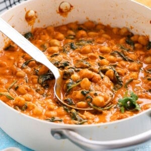 chickpea and spinach curry in a white pan.