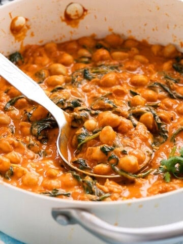 chickpea and spinach curry in a white pan.