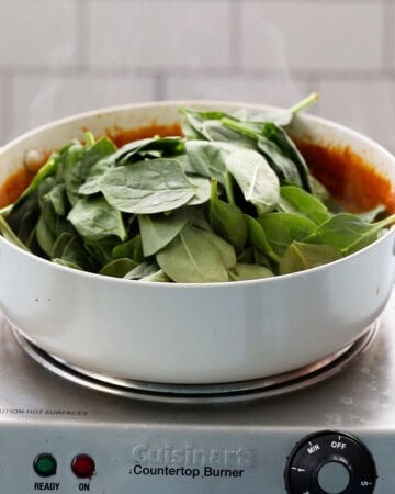 green spinach leaves in a white pan.