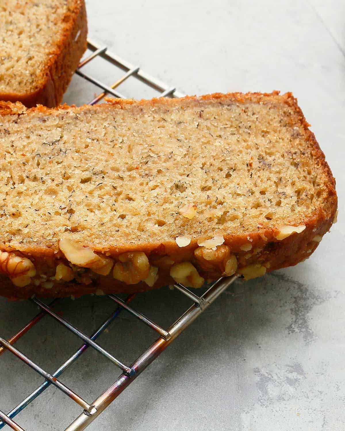 a rectangular slice of banana bread placed on a wire rack.