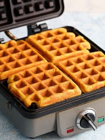 4 cooked waffles in a waffle iron.