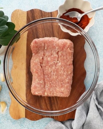 pink ground chicken in a glass bowl.
