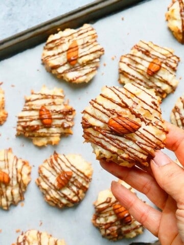 a hand holding one almond joy cookie.