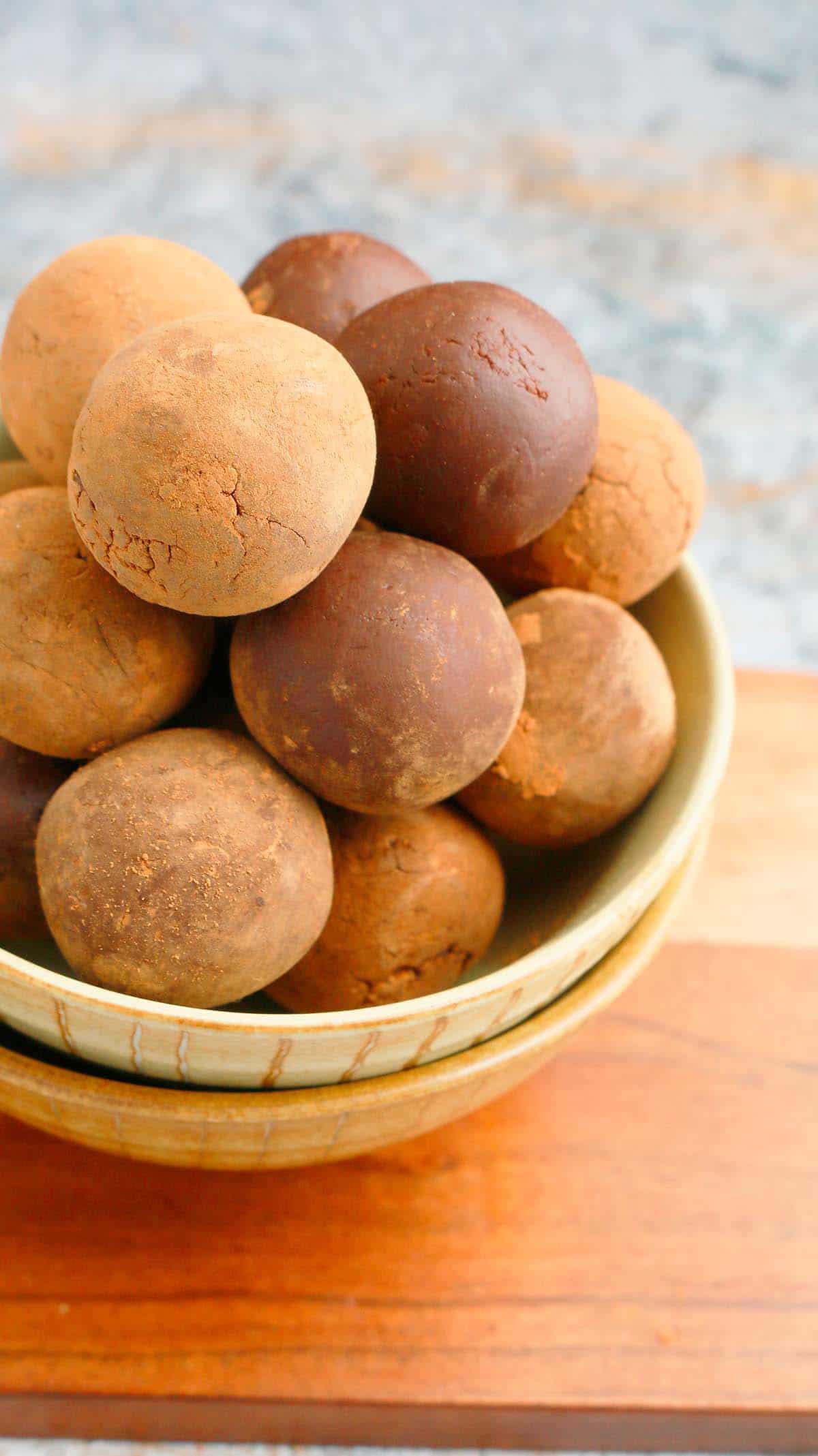 chocolate truffles piled high in 2 bowls stacked on top of each other.
