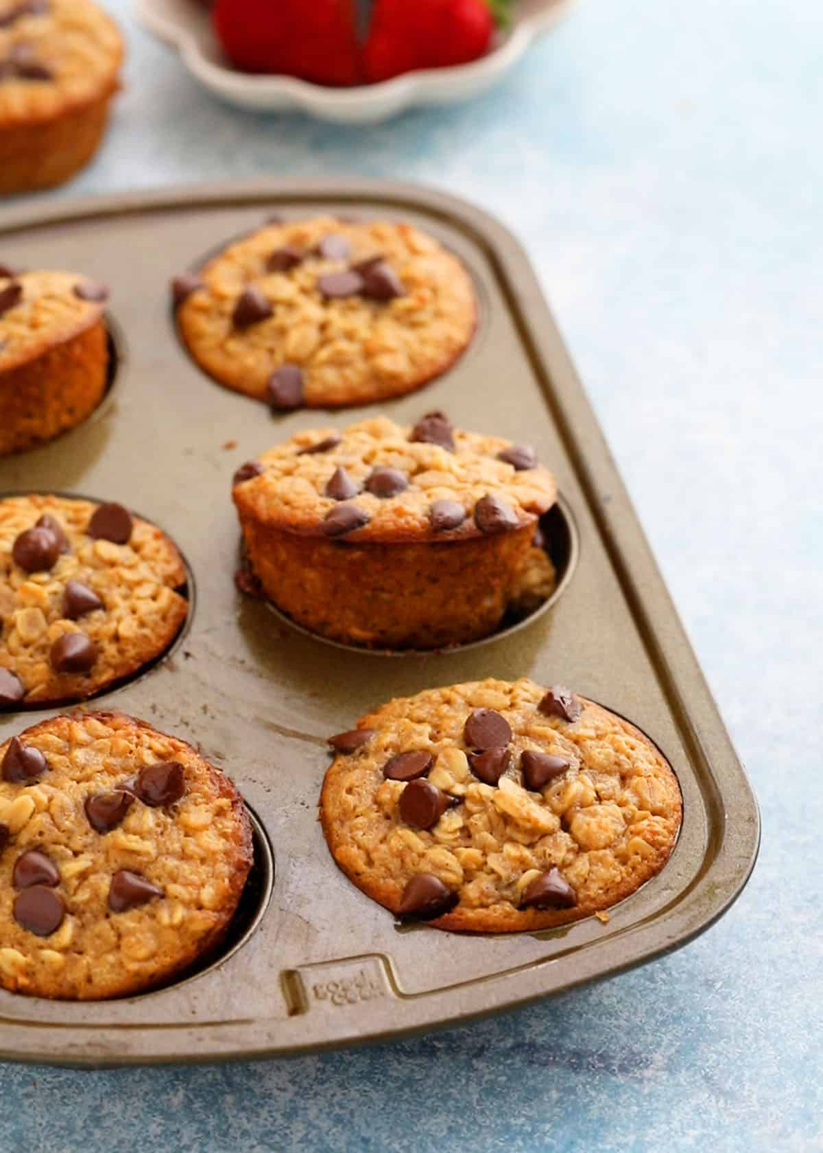 6 baked oatmeal muffins in a metal muffin pan.