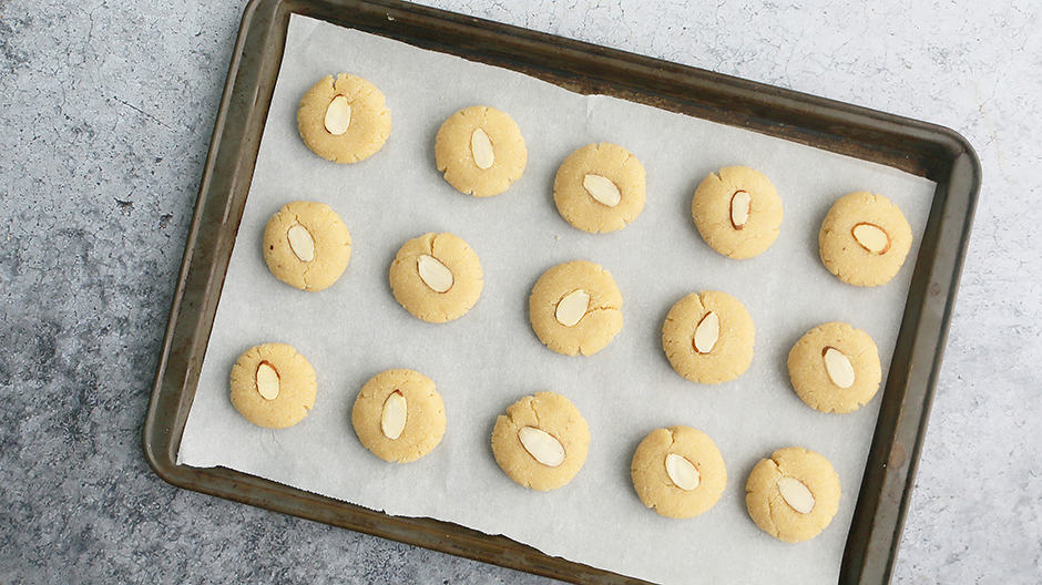 sheet pan lined with parchment paper with shaped almond flour cookie dough ready to be baked